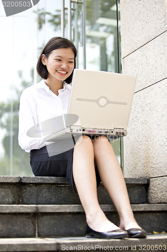 Image of Asian young female executive using laptop