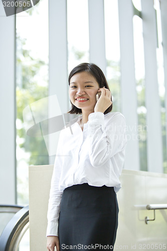 Image of Asian young female executive talking on smart phone