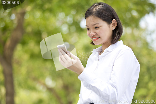 Image of Asian young female executive looking at smart phone