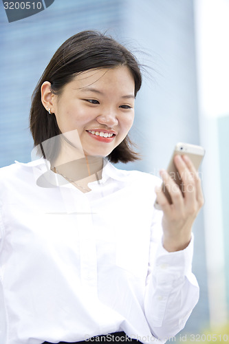 Image of Asian young female executive looking at smart phone