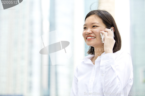 Image of Asian young female executive talking on smart phone