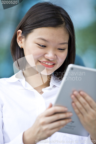 Image of Asian young female executive using tablet