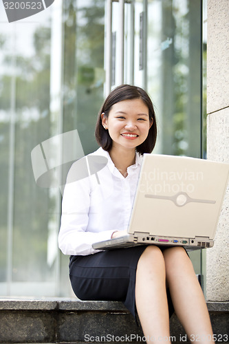 Image of Asian young female executive using laptop