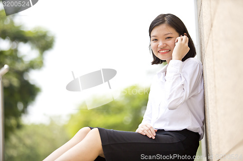 Image of Asian young female executive talking on smart phone
