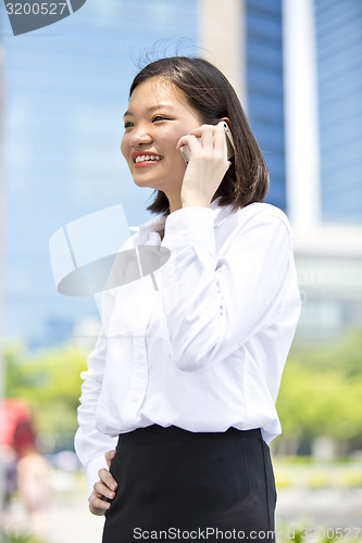 Image of Asian young female executive talking on smart phone