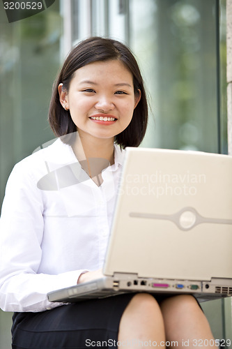 Image of Asian young female executive using laptop
