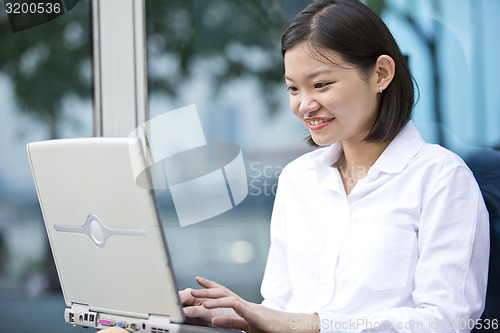 Image of Asian young female executive using laptop