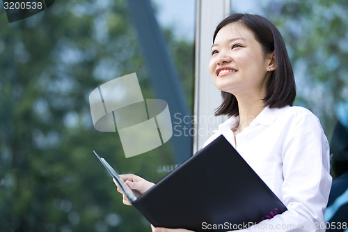 Image of Asian young female executive holding file smiling