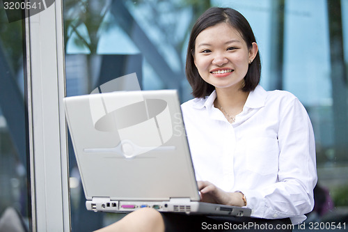 Image of Asian young female executive using laptop