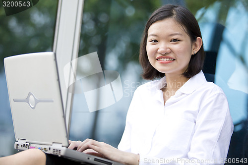 Image of Asian young female executive using laptop