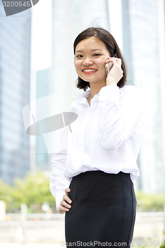 Image of Asian young female executive talking on smart phone