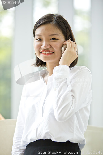 Image of Asian young female executive talking on smart phone