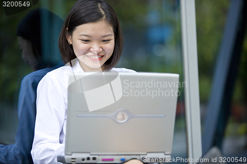 Image of Asian young female executive using laptop