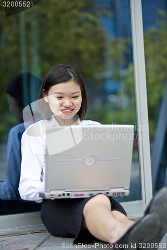 Image of Asian young female executive using laptop