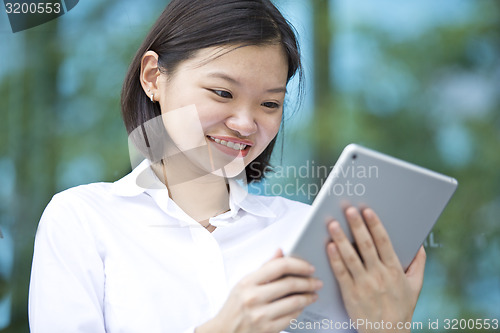 Image of Asian young female executive using tablet