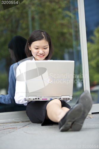 Image of Asian young female executive using laptop