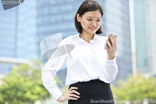 Image of Asian young female executive looking at smart phone