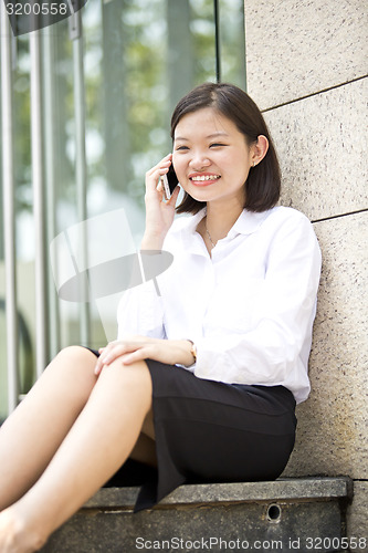 Image of Asian young female executive talking on smart phone