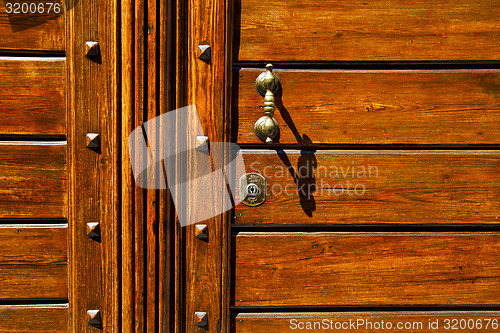 Image of  knocker in a   closed wood door olgiate olona varese italy