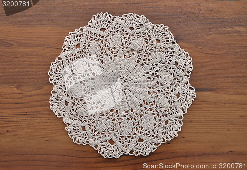 Image of Lace doily on dark wood