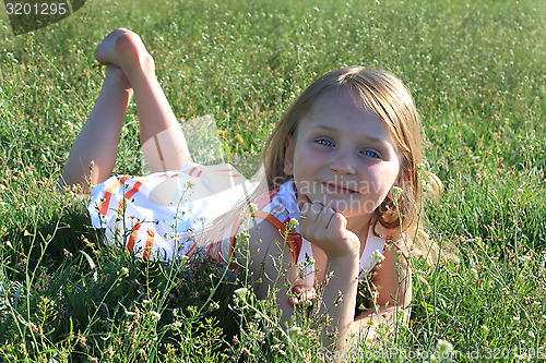 Image of portrait of little girl lying on the grass