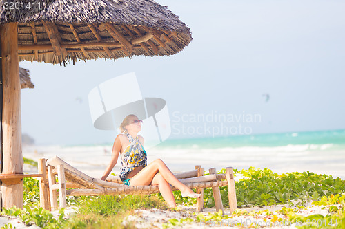 Image of Woman sunbathing on tropical beach.