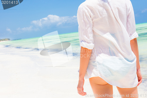 Image of Woman on the beach in white shirt. 