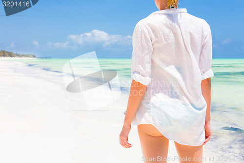 Image of Woman on the beach in white shirt. 