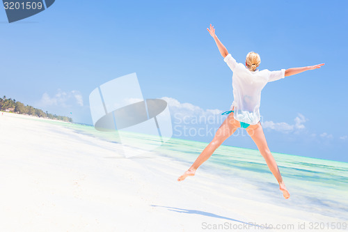 Image of Beautiful Girl Jumping on Tropical Beach.