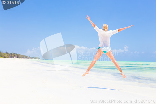 Image of Beautiful Girl Jumping on Tropical Beach.