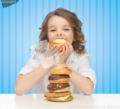 Image of happy little girl eating junk food