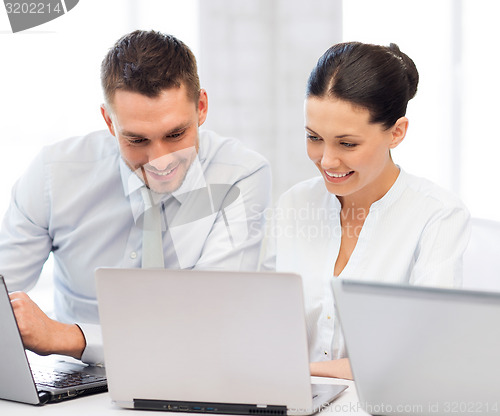 Image of group of people working with laptops in office