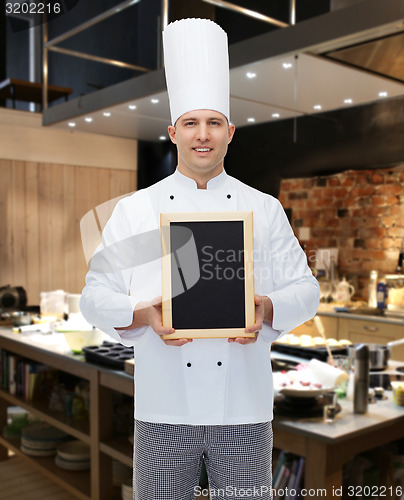 Image of happy male chef cook holding blank menu board