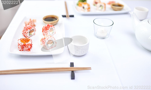 Image of close up of woman eating sushi at restaurant