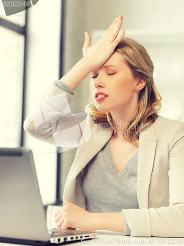 Image of businesswoman holding her head with hand