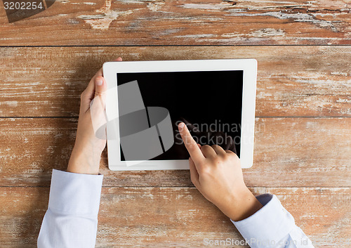 Image of close up of female hands with tablet pc on table