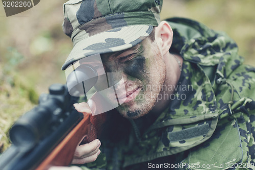 Image of soldier or hunter shooting with gun in forest