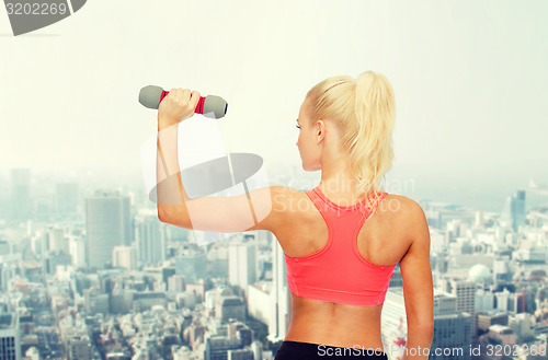 Image of young sporty woman with light dumbbell