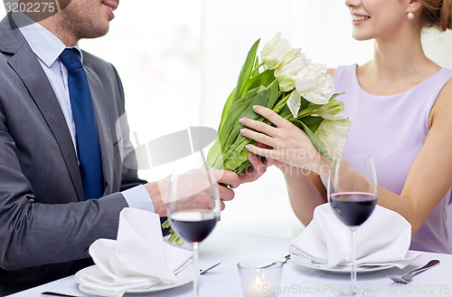 Image of young couple with glasses of wine at restaurant