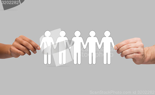 Image of hands holding paper chain people