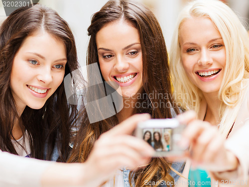 Image of beautiful girls taking picture in cafe in city