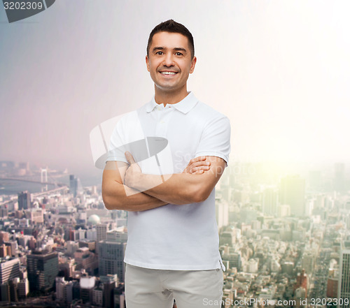 Image of smiling man in white t-shirt over city background