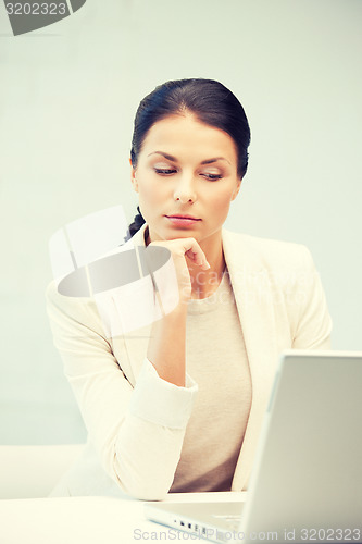 Image of pensive woman with laptop computer