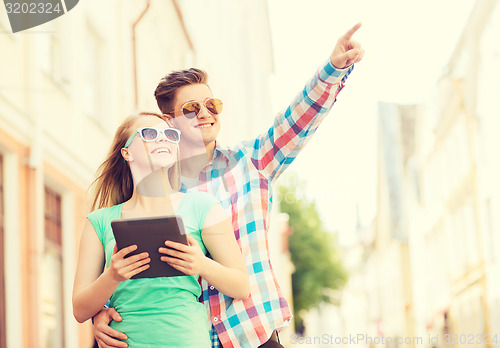 Image of smiling couple with tablet pc in city