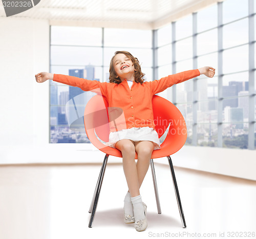 Image of happy little girl sitting on designer chair