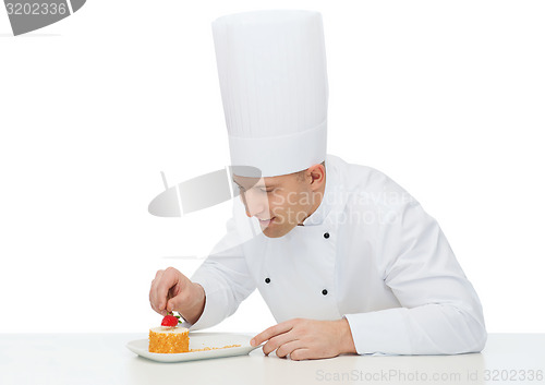 Image of happy male chef cook decorating dessert