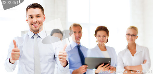 Image of businessman in office showign thumbs up