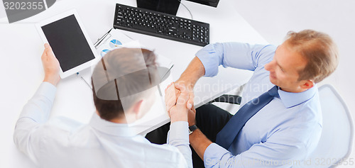 Image of businessmen shaking hands in office