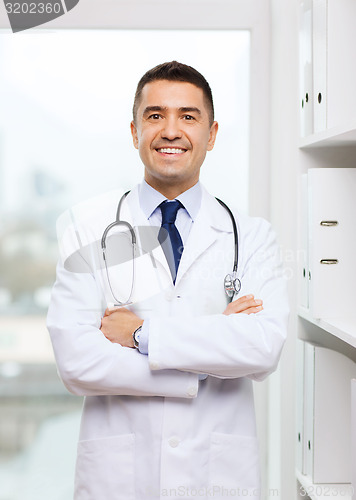 Image of smiling doctor in white coat at medical office