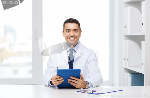 Image of smiling male doctor in white coat with tablet pc